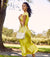 Woman wearing a silk yellow dress with a white leather crossbody bag worn over her arm