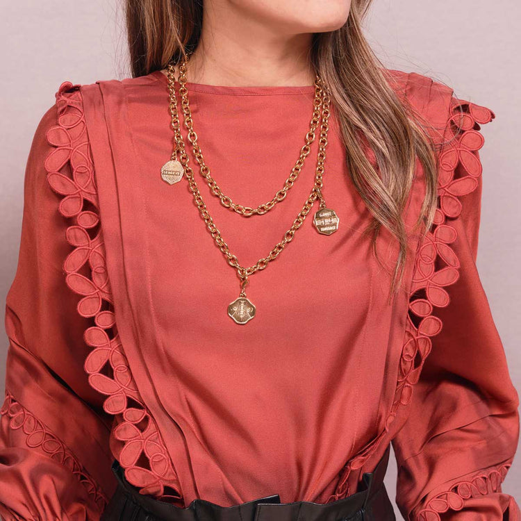 Three Ponte Vecchio Pendants attached to Gold Chain Necklace on neck of woman with fair skin and salmon blouse