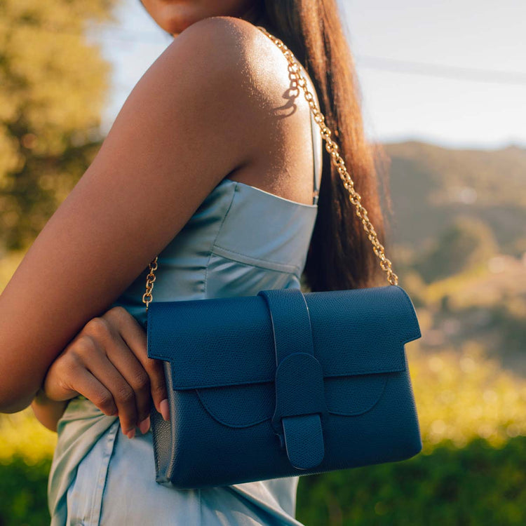 model wearing shoulder bag with beveled shoulder chain 