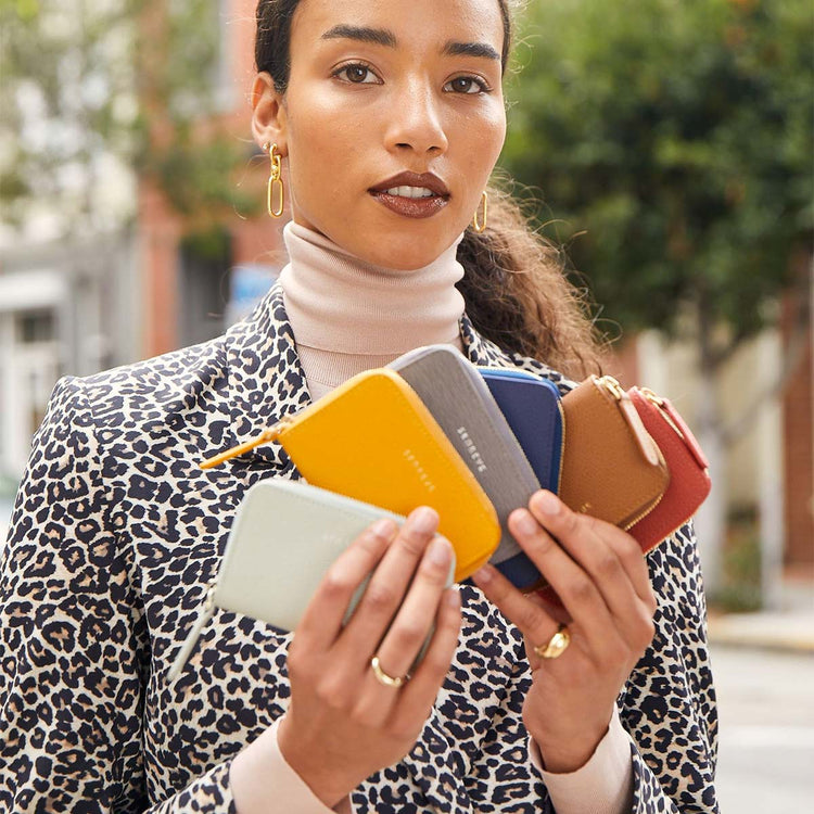 model holding multiple card wallets