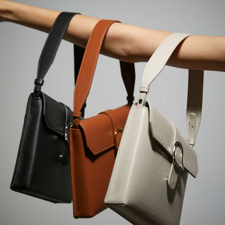 womans arm holding 3 saddle bags