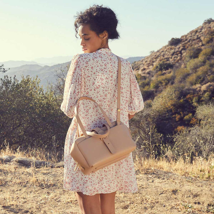 woman wearing a white dress with a doctor bag over her body