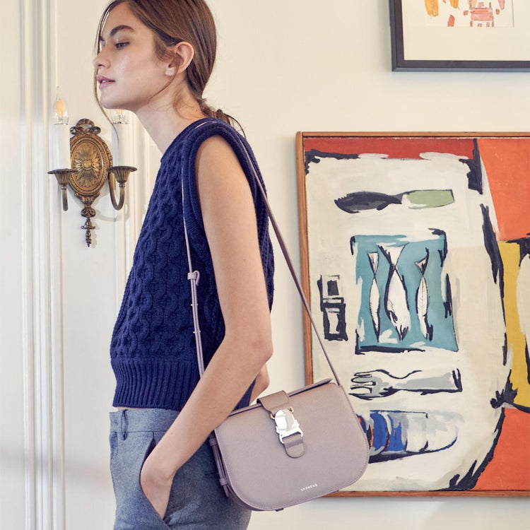 brunette woman wearing a purple crossbody bag over her shoulder